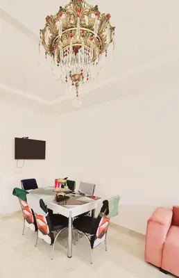a dining room with a table and a chandelier at Apartment Fes Urban Elegance - Garden & Pool in Fès