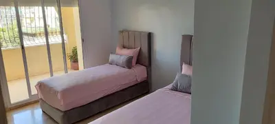 a bedroom with two beds and a window at Apartment Fes Urban Elegance - Garden & Pool in Fès