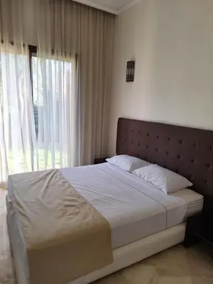 a bed in a bedroom with a large window at Villa des oliviers in Marrakech