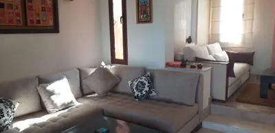 a living room with a couch with pillows on it at Villa des oliviers in Marrakech