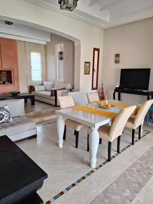 a living room with a table and a piano at Villa des oliviers in Marrakech