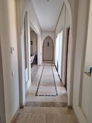 an empty hallway with white walls and a tile floor at Villa des oliviers in Marrakech