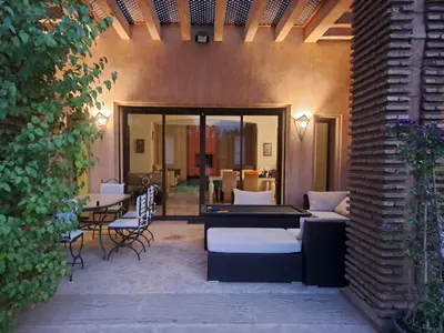 a patio with couches and a table and chairs at Villa des oliviers in Marrakech