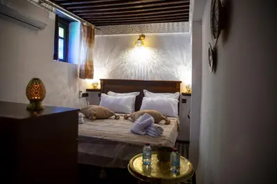 a bedroom with a bed with two pillows on it at Riad LalaMoune in Fès