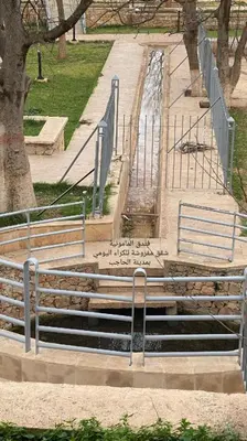 a group of benches in a park with a fountain at hôtel mamounia el hajeb in El Hajeb