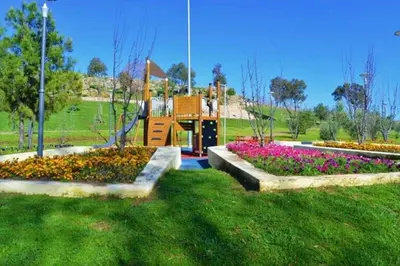 a park with a playground with flowers in the grass at hôtel mamounia el hajeb in El Hajeb