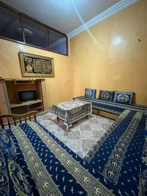 a bedroom with two beds and a tv at Belo appart bassatine in Meknès