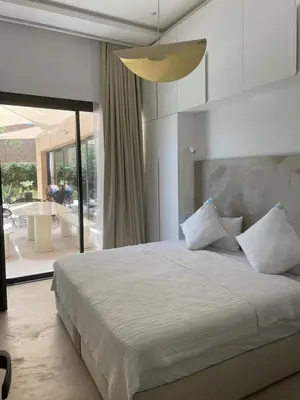 a bedroom with a large bed and a pendant light at Palmeria luxery in Marrakech