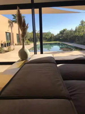 a living room with a couch and a palm tree at Palmeria luxery in Marrakech