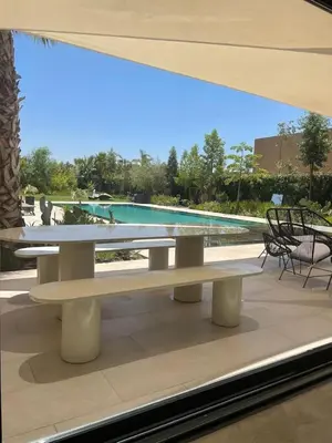 a table and chairs in front of a swimming pool at Palmeria luxery in Marrakech