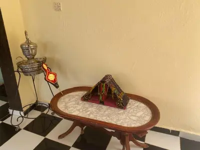 a table in a room with a lamp and a table with a tableablishthritis at Gite Cèdre Gouraud in Azrou