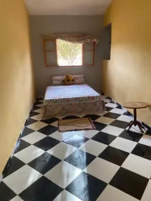 a room with a bed and a checkered floor at Gite Cèdre Gouraud in Azrou