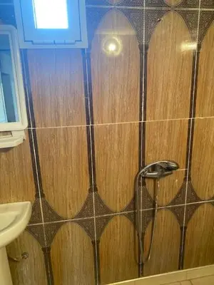 a bathroom with a shower with wooden walls and a sink at Gite Cèdre Gouraud in Azrou