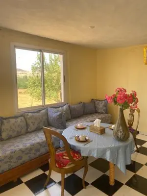 a living room with a couch and a table with a vase at Gite Cèdre Gouraud in Azrou