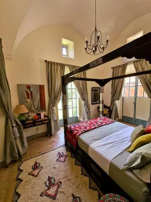 a bedroom with a canopy bed and a chandelier at LA PORTE AU LION - Marrakech in Marrakech