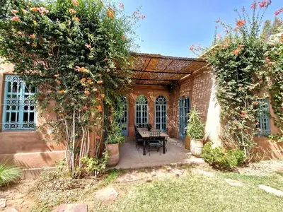 an outdoor patio with a table and two trees at LA PORTE AU LION - Marrakech in Marrakech