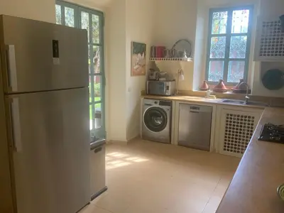 a kitchen with a refrigerator and a washing machine at LA PORTE AU LION - Marrakech in Marrakech