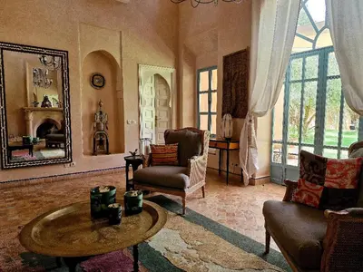 a living room with a table and chairs and a mirror at LA PORTE AU LION - Marrakech in Marrakech