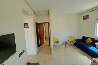 a living room with a blue couch and two chairs at Appartement Centre Ville - ATLAS in Fès
