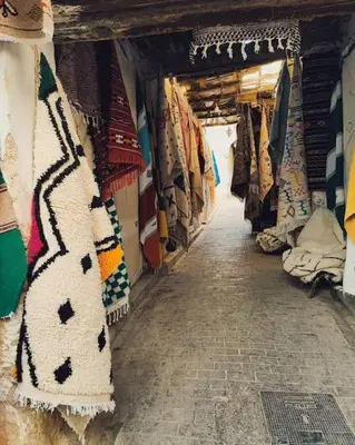 an aisle of a market with blankets and scarves at Appartement Centre Ville - ATLAS in Fès