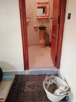 a hallway with a door and a basket on a rug at Kasbah ADRAR in Imilchil