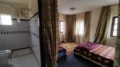 a small bedroom with a bed and a shower at Kasbah ADRAR in Imilchil