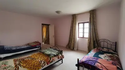 a bedroom with two beds and a window at Kasbah ADRAR in Imilchil