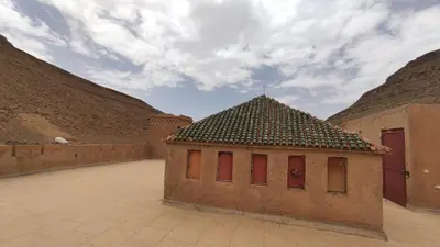 a small building with red doors in a courtyard at Kasbah ADRAR in Imilchil