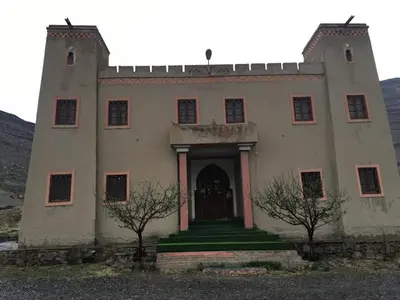 an old house with two trees in front of it at Kasbah ADRAR in Imilchil