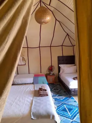 a room with two beds in a tent at Sahara Elegance Camp in Merzouga