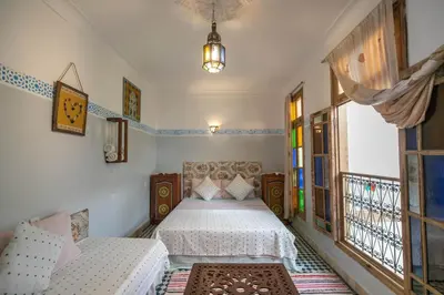 a bedroom with two beds and a window at Dar Lala Mama in Fès