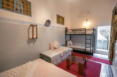 a room with two bunk beds and a table at Dar Lala Mama in Fès