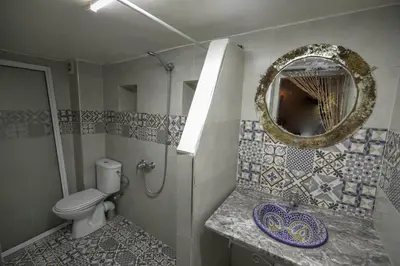 a bathroom with a toilet and a mirror at Dar Lala Mama in Fès