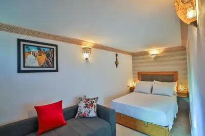 a hotel room with a bed and a couch at Riad Ridaya in Fès