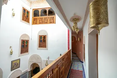 a staircase in a building with wooden doors and windows at Riad Ridaya in Fès