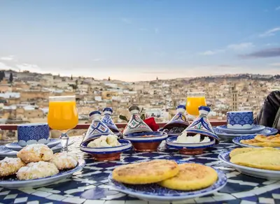 a table with plates of food and glasses of orange juice at Riad Ridaya in Fès