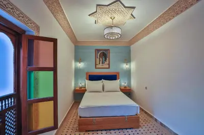 a bedroom with a bed and a chandelier at Riad Ridaya in Fès