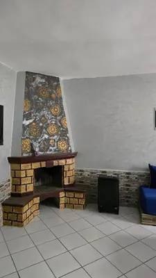 a living room with a brick fireplace with a wall at Luxury Ifrane House in Ifrane