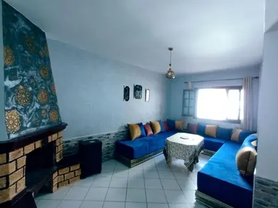 a living room with a blue couch and a table at Luxury Ifrane House in Ifrane