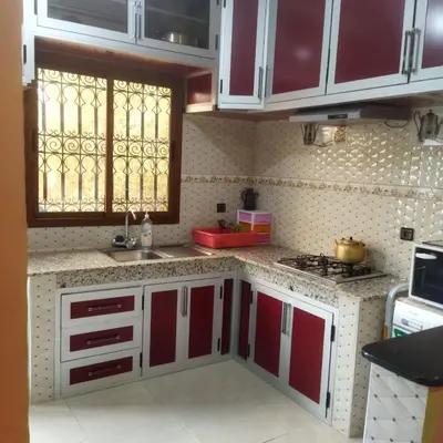 a kitchen with red and white cabinets and a window at Chez Sondos in Marrakech