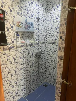 a bathroom with a shower with blue and white tiles at Chez Sondos in Marrakech