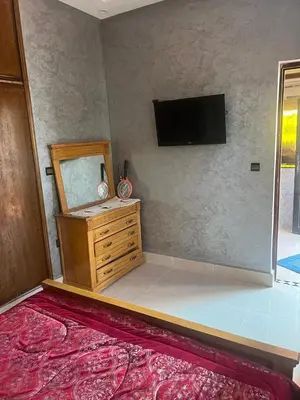 a bedroom with a dresser and a flat screen tv at Chez Sondos in Marrakech
