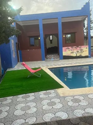 a pink chair sitting on a lawn next to a pool at Chez Sondos in Marrakech