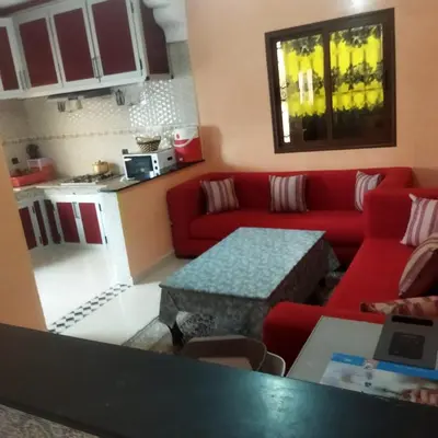 a living room with a red couch and a table at Chez Sondos in Marrakech