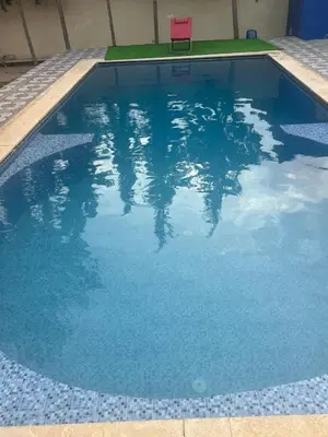 a swimming pool with a chair in the water at Chez Sondos in Marrakech
