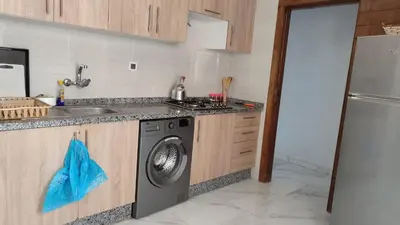 a kitchen with a sink and a washing machine at Coin vert in Fès