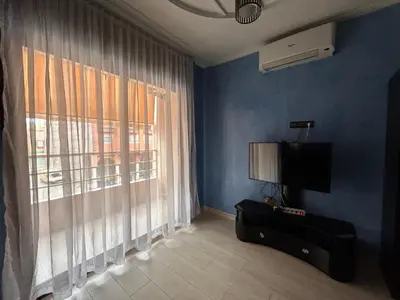 a blue room with a television and a window at 800 Miles of Travel in Ouarzazate