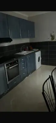 a kitchen with blue cabinets and a sink and a microwave at 800 Miles of Travel in Ouarzazate