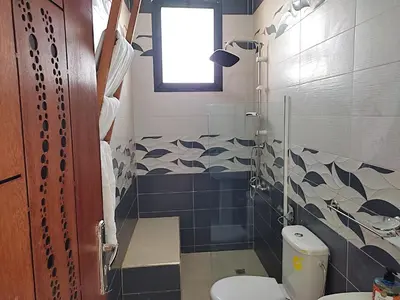 a bathroom with a toilet and a window at Lina Village in Al Hachlaf
