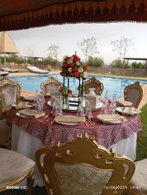 a table with chairs and a table with flowers on it at Lina Village in Al Hachlaf